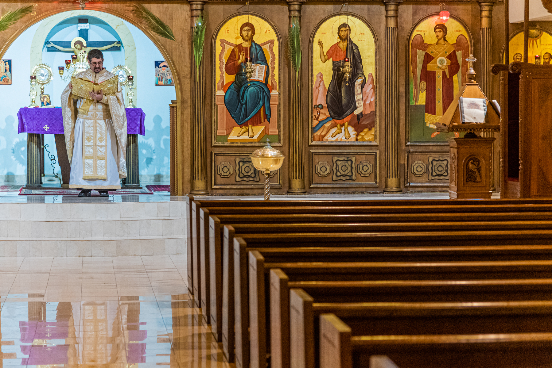 4/12/2020 - Atlanta, GA - Fr. Gabriel Tannoush reads the Gospel to an empty church on Orthodox Palm Sunday. Due to Covid-19, the church was closed to parishioners, but services continued via social media streaming.