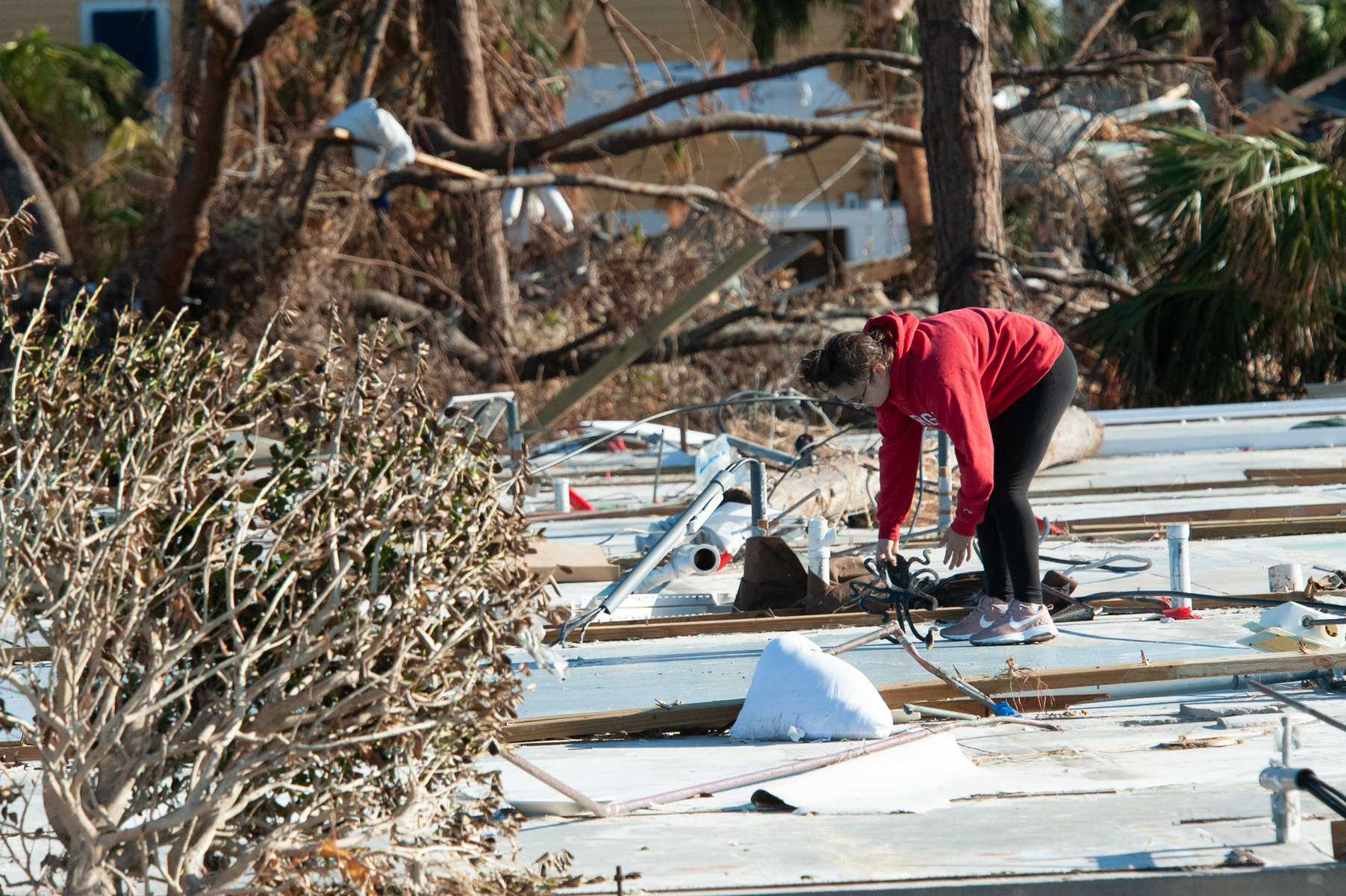 October 18, 2018 - Mexico Beach, FL - A young girl shifts through what is left of her parents vacation home in Mexico Beach, Florida after Hurricane Michael as passed through the area on October 15, 2018 in Mexico Beach, Florida.  The hurricane hit the Florida Panhandle as a category 5 storm causing massive damage and claimed the lives of more then a dozen people.